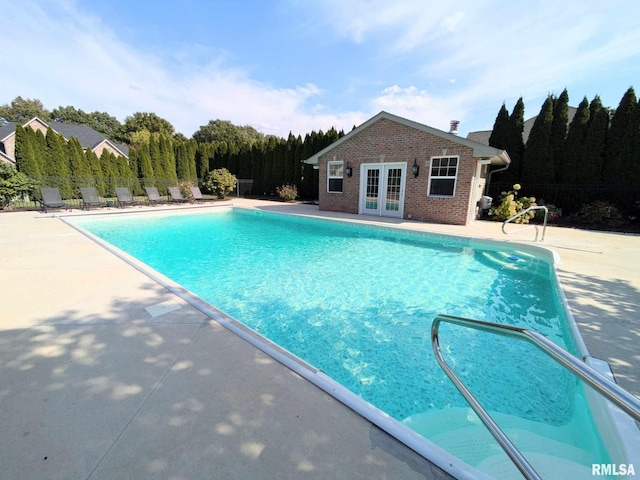 view of pool with a patio area, french doors, and an outdoor structure