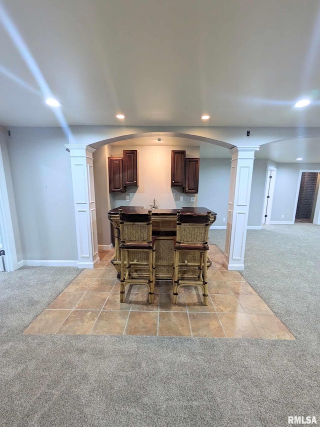 dining area featuring ornate columns and light carpet