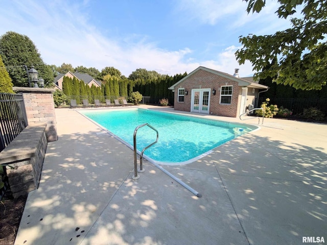 view of pool featuring french doors, a patio, and an outdoor structure