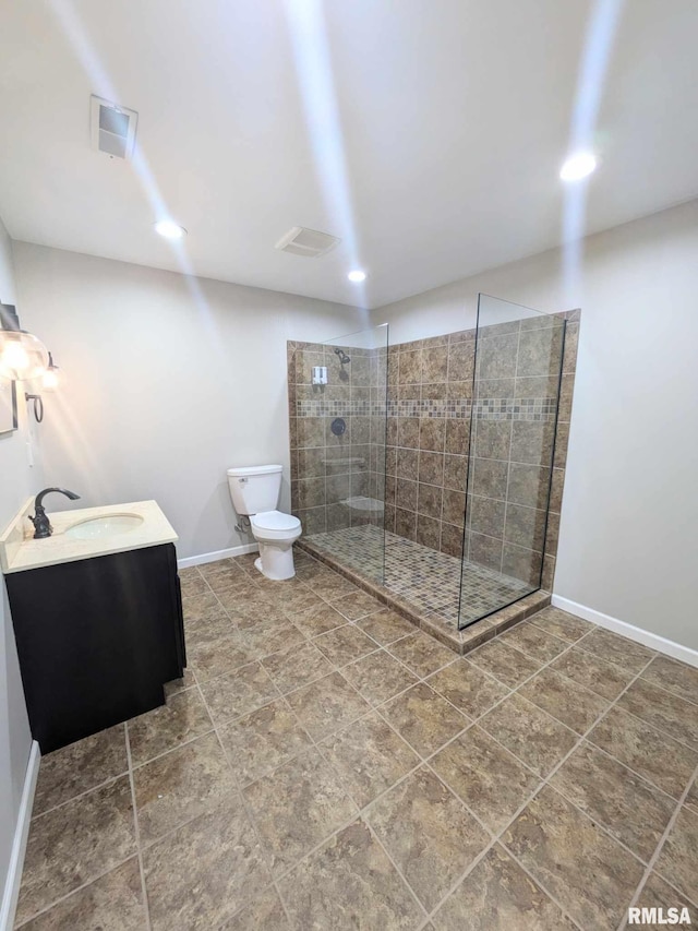 bathroom featuring vanity, toilet, and a tile shower