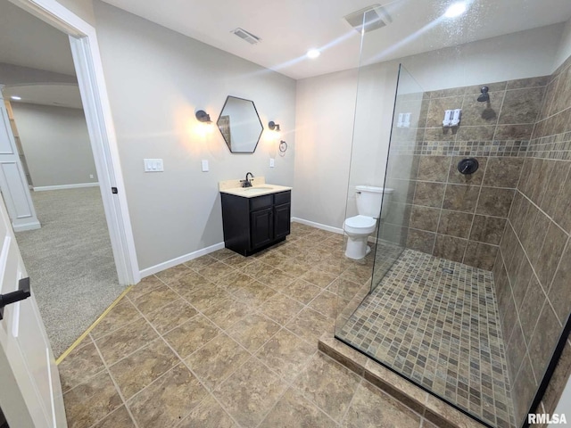 bathroom with vanity, toilet, and a tile shower