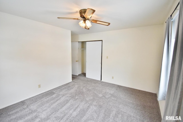 unfurnished bedroom featuring ceiling fan, a closet, and light colored carpet