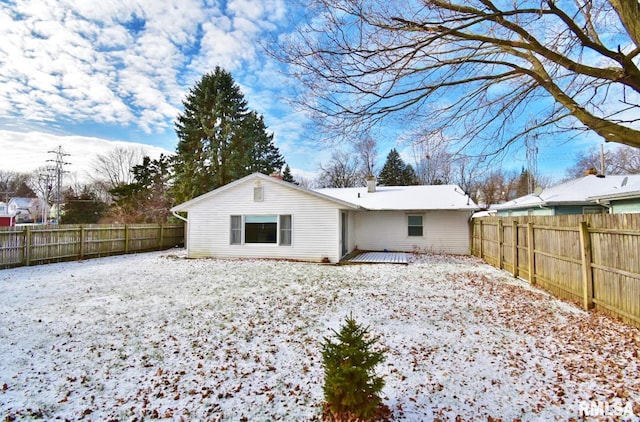 snow covered back of property featuring a deck