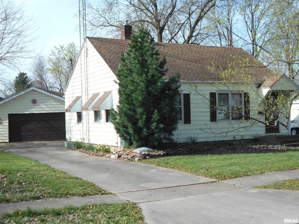 view of side of home with a garage, a yard, and an outbuilding