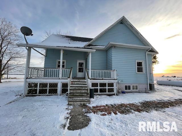 snow covered house with covered porch