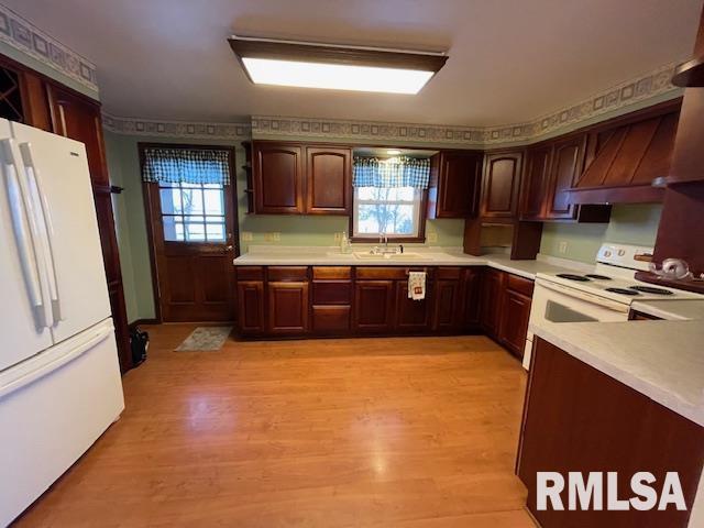 kitchen featuring a wealth of natural light, light hardwood / wood-style flooring, and white appliances