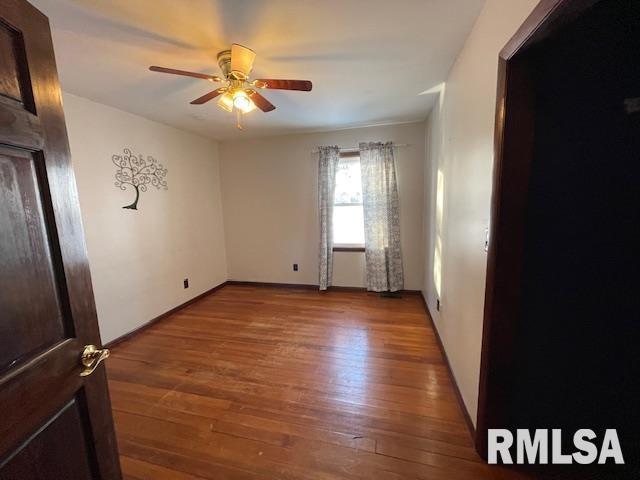 empty room with hardwood / wood-style flooring and ceiling fan