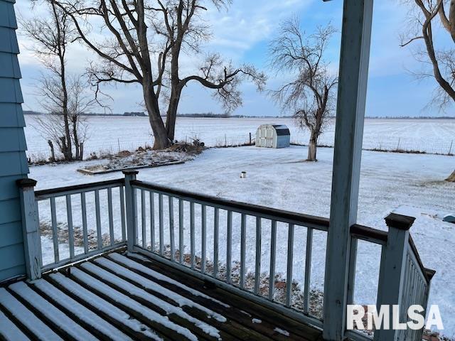 snow covered deck featuring a storage unit