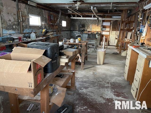 miscellaneous room featuring a workshop area and concrete floors