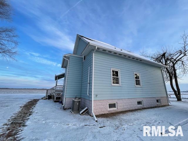 view of snowy exterior with central AC