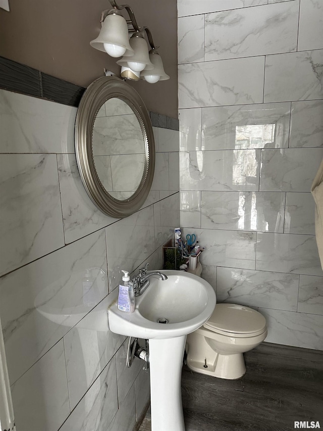 bathroom featuring tile walls, wood-type flooring, and toilet