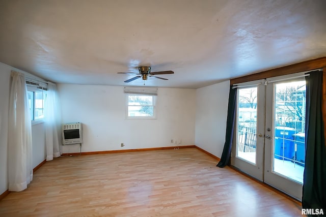 empty room featuring french doors, heating unit, light hardwood / wood-style flooring, and ceiling fan