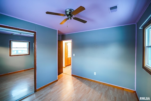 unfurnished bedroom featuring ceiling fan, crown molding, and light hardwood / wood-style flooring