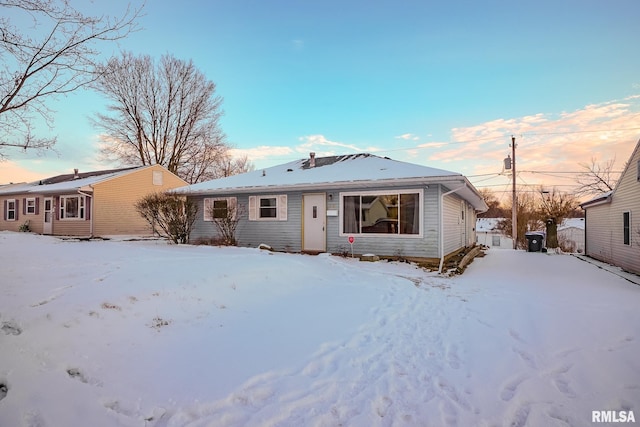 view of snow covered back of property