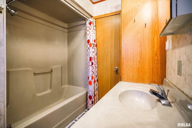 bathroom with shower / bathtub combination with curtain and sink