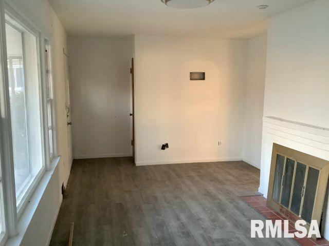 unfurnished living room with a fireplace and dark hardwood / wood-style flooring