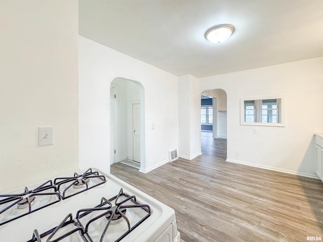 kitchen featuring white cabinets, light hardwood / wood-style floors, and white range oven