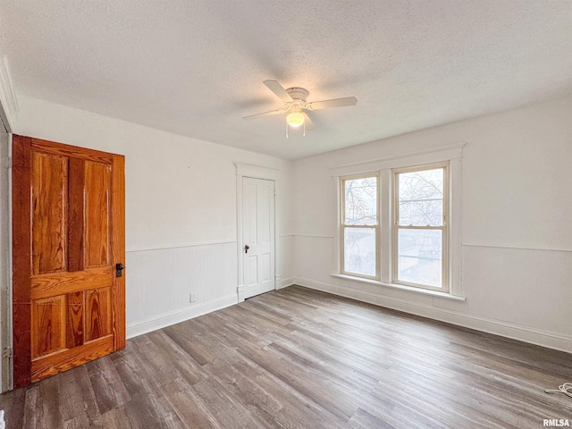 unfurnished room featuring a textured ceiling, hardwood / wood-style flooring, and ceiling fan