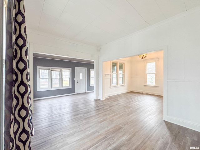 unfurnished living room with wood-type flooring and a chandelier