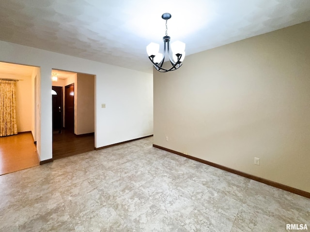 unfurnished room with a notable chandelier