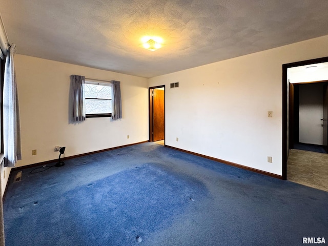 unfurnished room with a textured ceiling and carpet floors