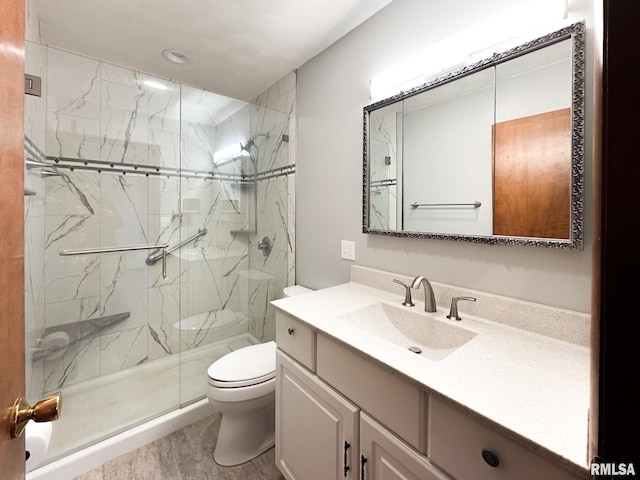 bathroom featuring hardwood / wood-style flooring, toilet, vanity, and a shower with shower door