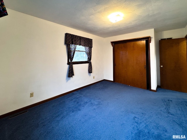 unfurnished bedroom featuring a textured ceiling and carpet floors