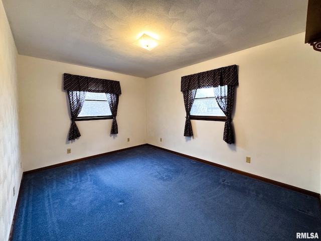 carpeted spare room featuring a textured ceiling