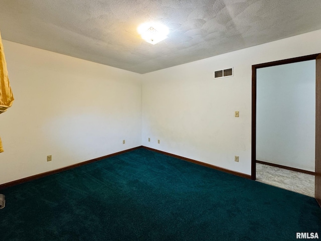 spare room featuring a textured ceiling and carpet floors