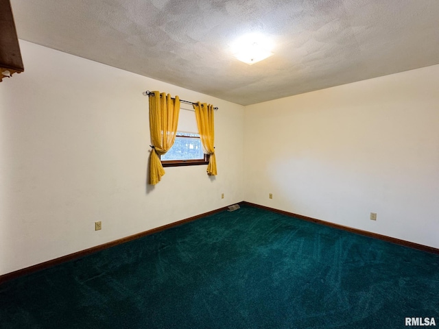 empty room with carpet and a textured ceiling