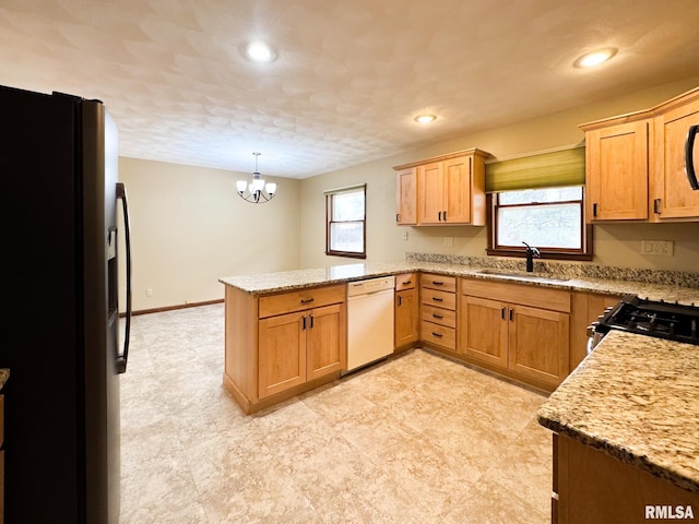 kitchen with pendant lighting, dishwasher, black refrigerator with ice dispenser, sink, and kitchen peninsula