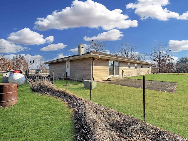 view of side of home with a yard