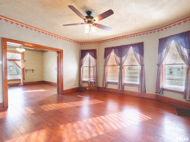 unfurnished room featuring hardwood / wood-style floors, plenty of natural light, and a textured ceiling