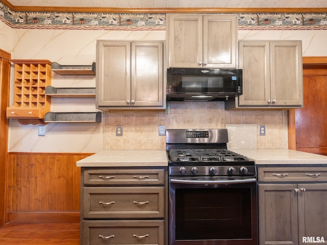 kitchen with wood-type flooring, tasteful backsplash, and stainless steel gas range oven