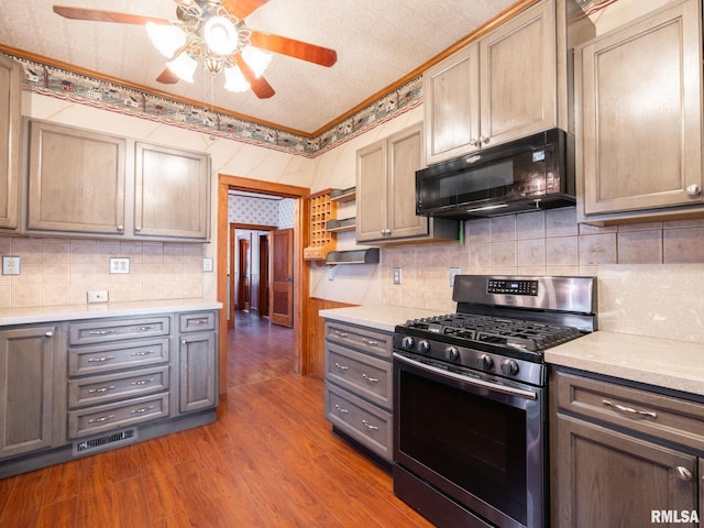 kitchen with wood-type flooring, backsplash, ornamental molding, and stainless steel range with gas stovetop