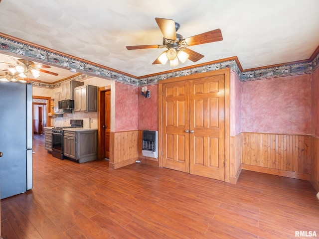 kitchen with hardwood / wood-style floors, stainless steel appliances, heating unit, and crown molding