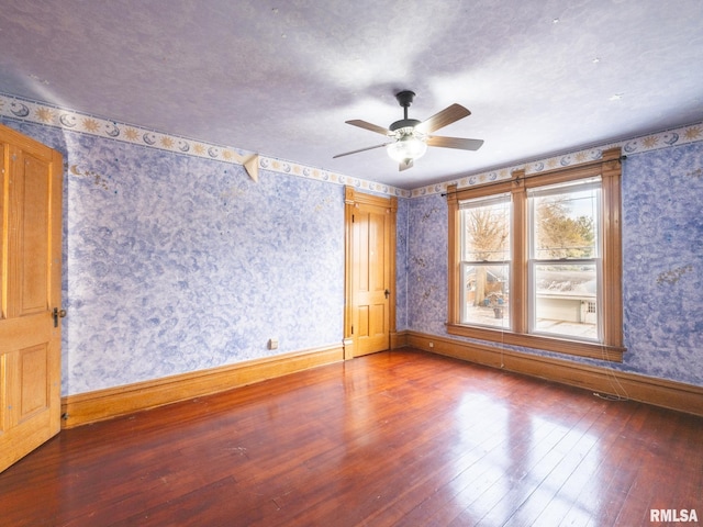 empty room with hardwood / wood-style floors and ceiling fan