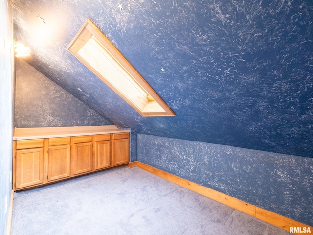 bonus room with light colored carpet and vaulted ceiling