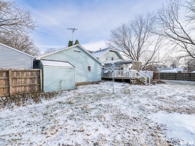 snow covered house featuring a wooden deck