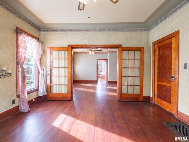 empty room with french doors, dark hardwood / wood-style flooring, and a healthy amount of sunlight