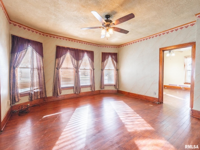 spare room featuring hardwood / wood-style floors, a textured ceiling, and a wealth of natural light