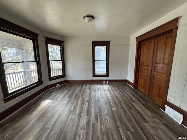 interior space with baseboards, visible vents, and dark wood-type flooring