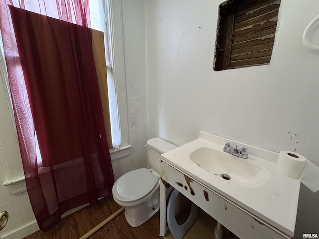 bathroom with toilet, wood-type flooring, and sink