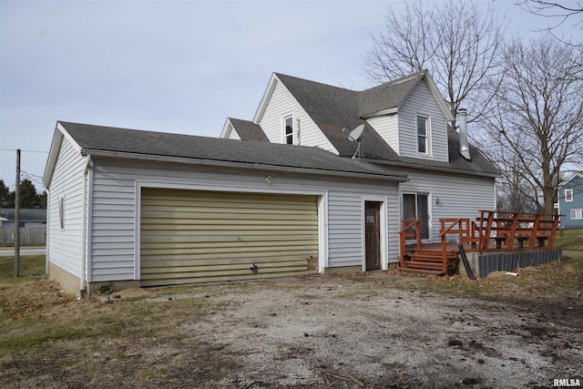 exterior space with a garage and a wooden deck