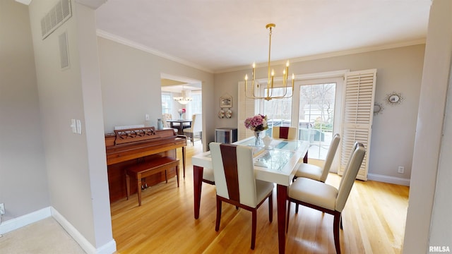 dining room with light hardwood / wood-style flooring, a wealth of natural light, and a chandelier