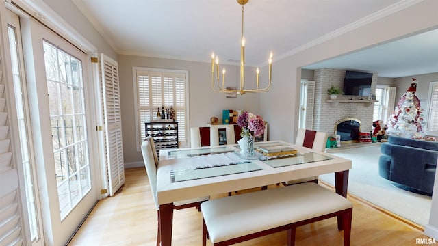 dining room featuring crown molding, a fireplace, and light hardwood / wood-style floors