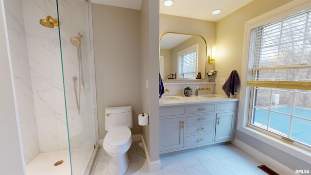 bathroom featuring a tile shower, vanity, and toilet