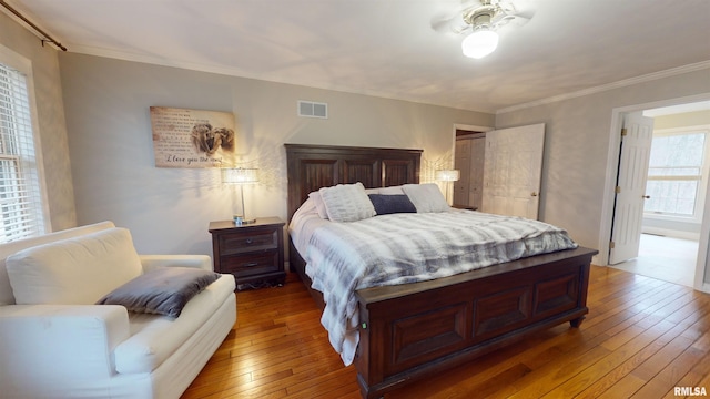 bedroom with crown molding and wood-type flooring