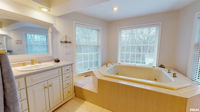 bathroom with tile patterned floors, vanity, and tiled tub