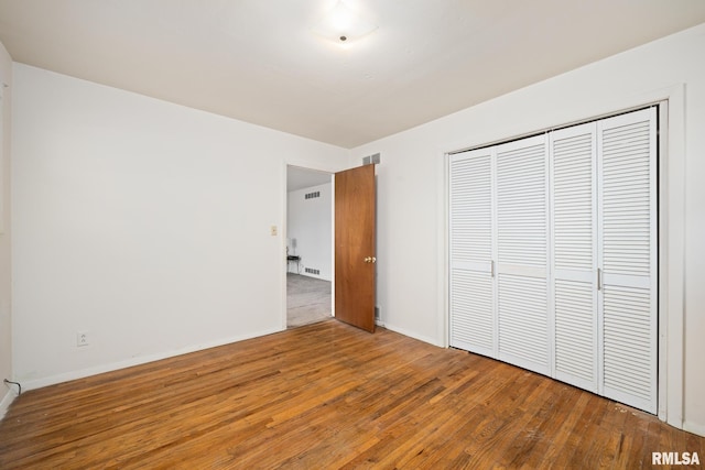 unfurnished bedroom featuring hardwood / wood-style floors and a closet